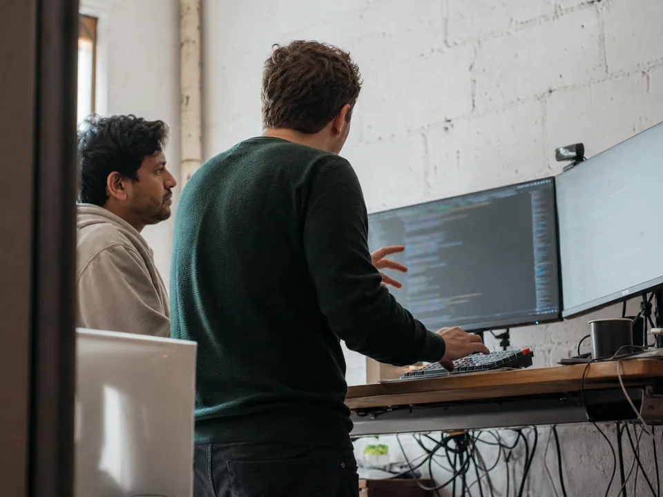 Two engineers pair programming at a standing desk