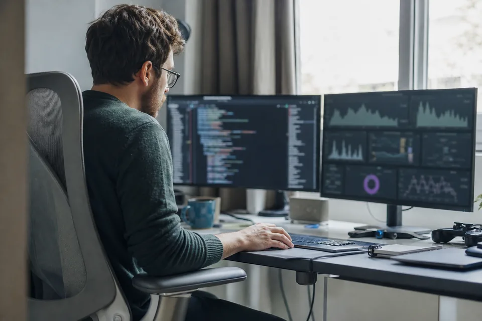 Developer at a desk with live data dashboards