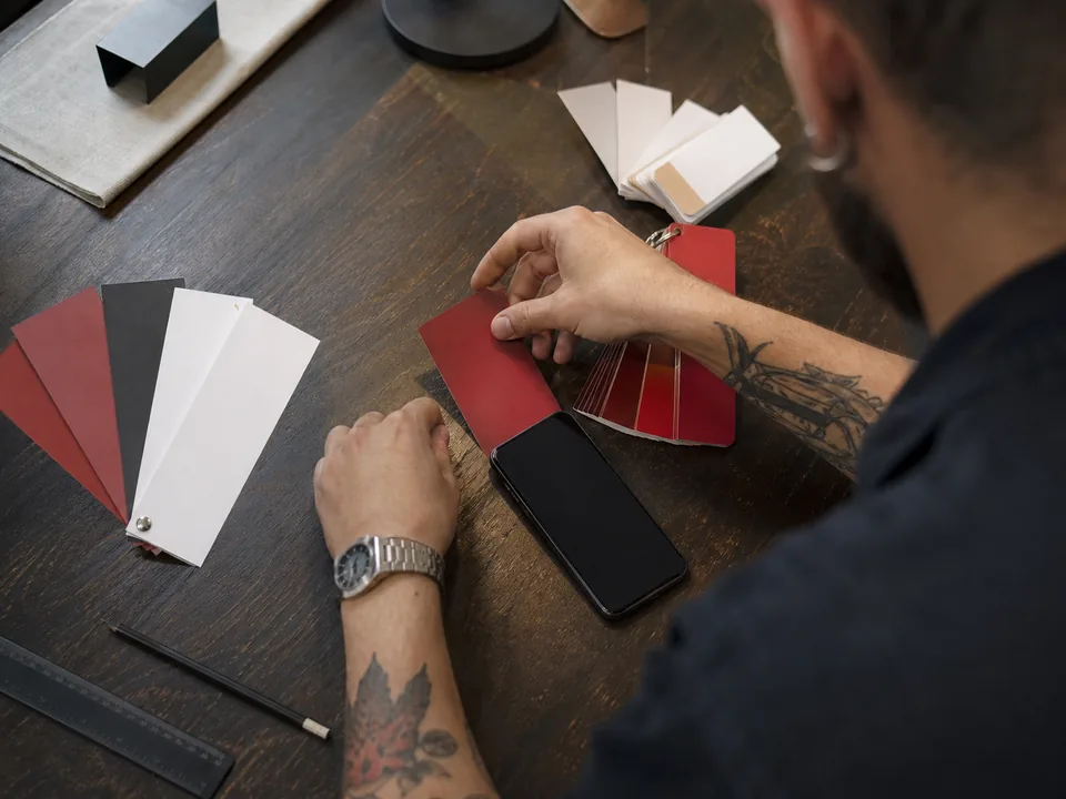 A designer matching red and black colour swatches next to a phone